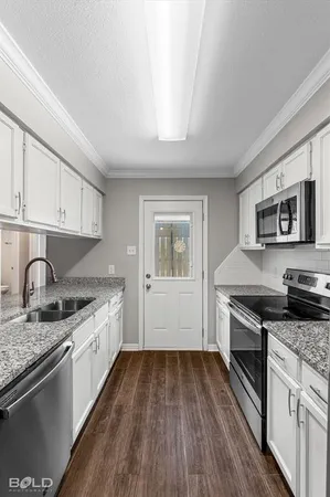 a kitchen with granite countertop stainless steel appliances and wooden cabinets
