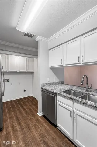 a kitchen with granite countertop a stove a sink dishwasher and cabinets with wooden floor