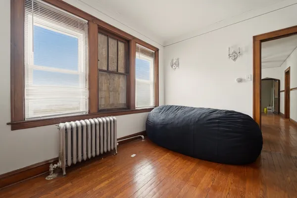 a view of a room that has wooden floor and a window