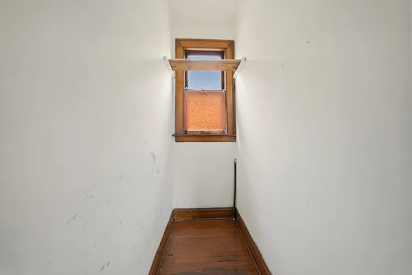 a view of a small space with wooden floor and a window