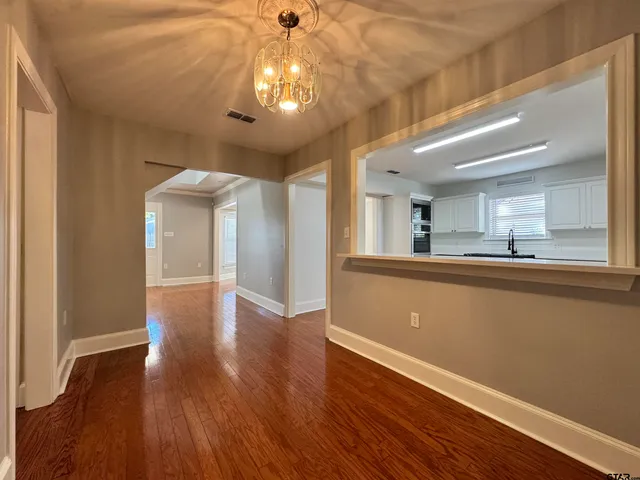 a view of a room with wooden floor and a ceiling fan