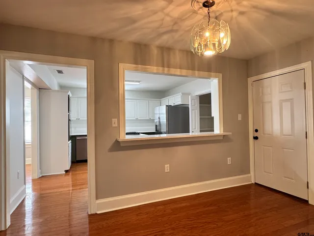 a view of a livingroom with wooden floor and a ceiling fan