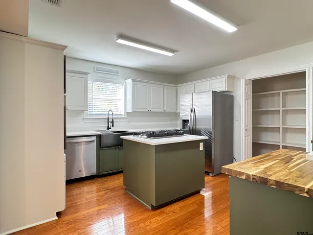 a kitchen with stainless steel appliances granite countertop a stove and a refrigerator