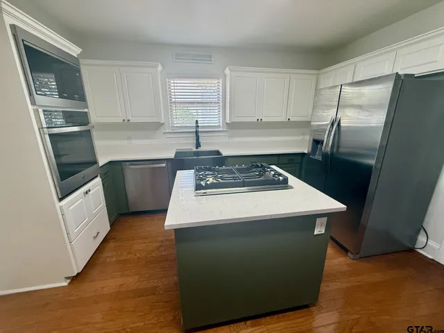 a kitchen with sink a refrigerator and wooden cabinets
