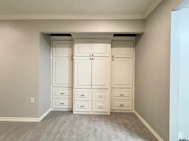 an empty room with a fireplace and cabinet