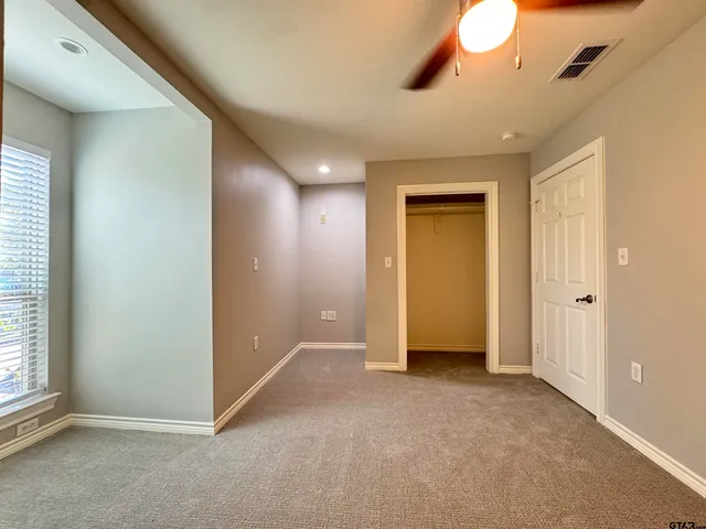 an empty room with closet and fan
