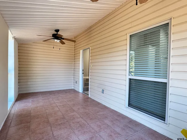a view of a house with a small yard and large tree