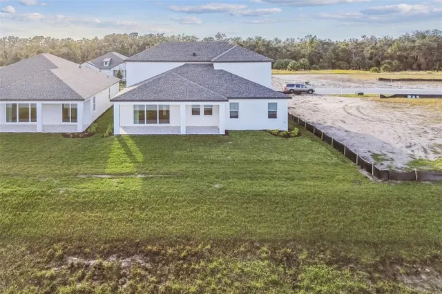a aerial view of a house next to a yard with an ocean view