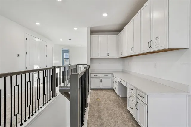 a kitchen with granite countertop white cabinets and stainless steel appliances
