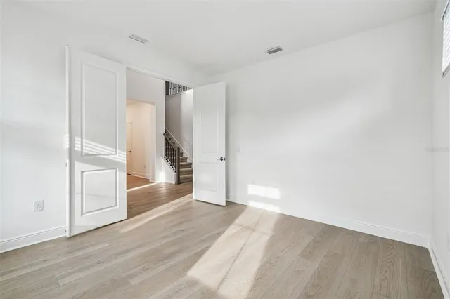 a view of empty room with wooden floor