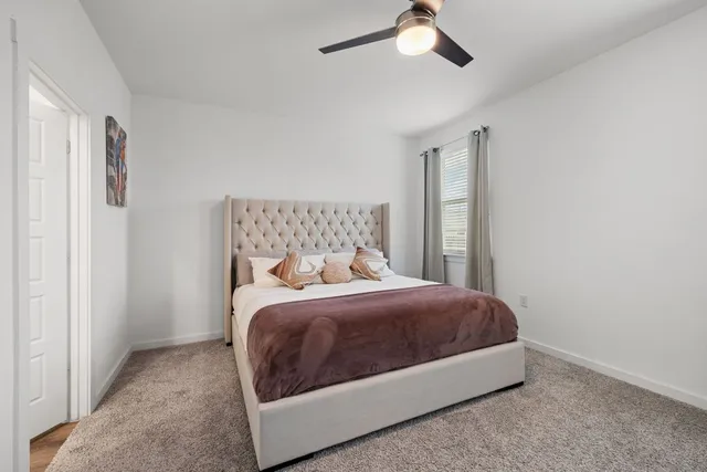 a bedroom with a bed lamp and a window