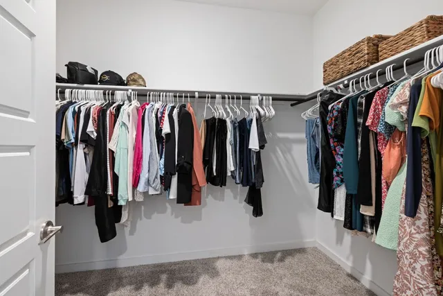 a large kitchen with stainless steel appliances a white table chairs and a refrigerator