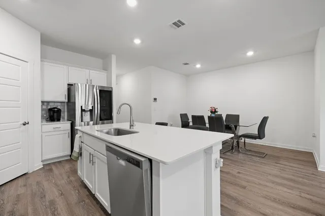 a view of kitchen island a sink and wooden floor