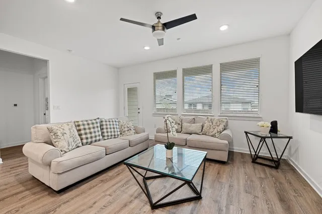 a living room with furniture kitchen view and a flat screen tv