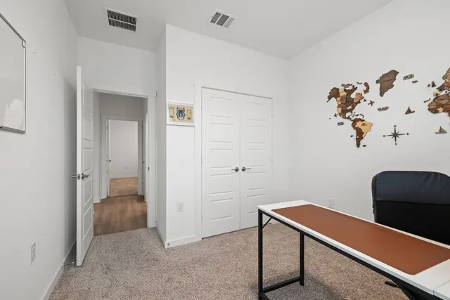 a view of a workspace with furniture and a window