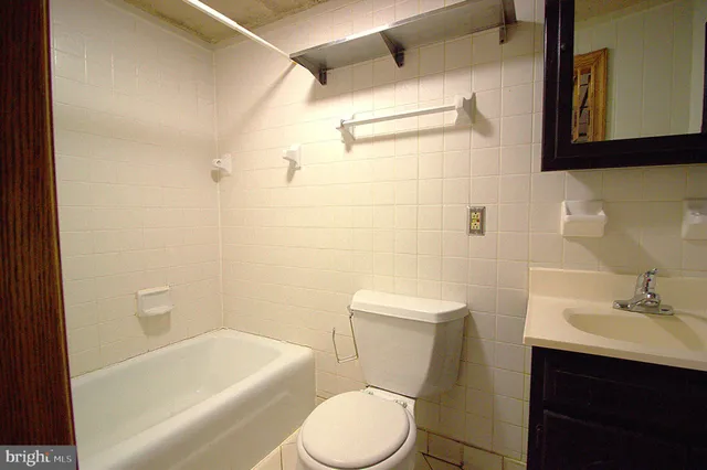 a white toilet sitting next to a bathroom sink and tub
