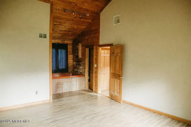 a view of a room with wooden floor and windows