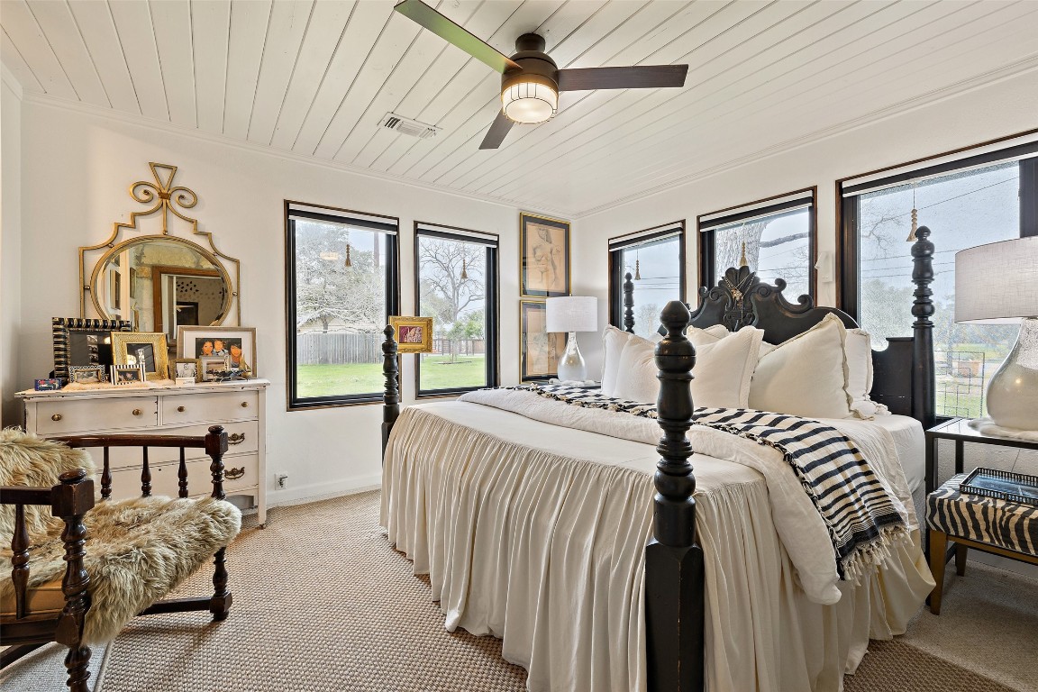 400 Lange Road Wimberley, TX 78676 - Photo 13 of 25 a bedroom with a bed a ceiling fan and a large window