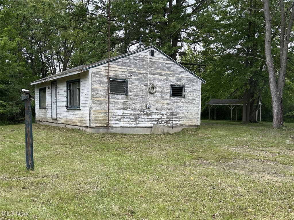 View of side of home featuring a lawn