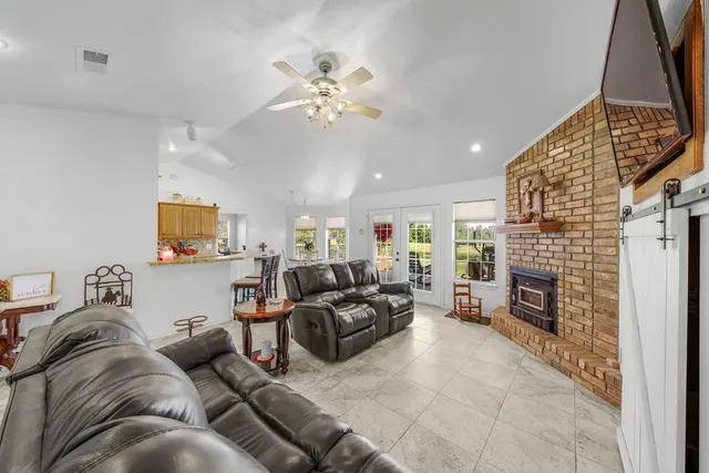 a living room with furniture a fireplace and a flat screen tv