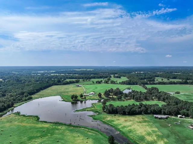 a view of a lush green outdoor space with a swimming pool and valleys in the background