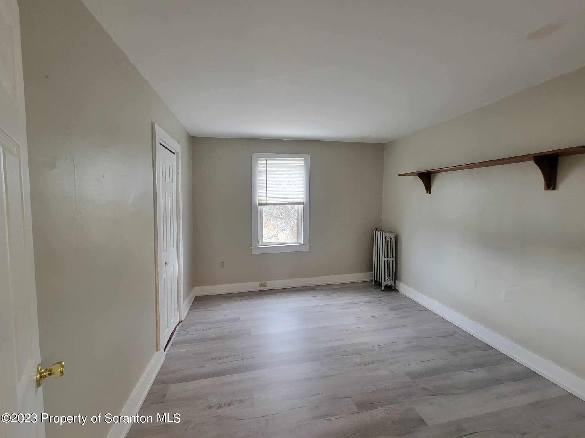 138 East Grove Street Taylor, PA 18517 - Photo 14 of 17 an empty room with wooden floor and windows