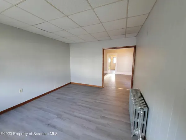 a view of an empty room with wooden floor