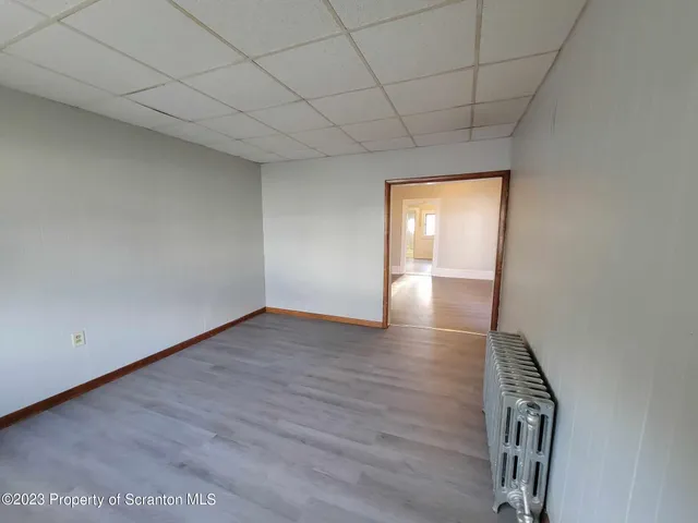 a view of an empty room with wooden floor