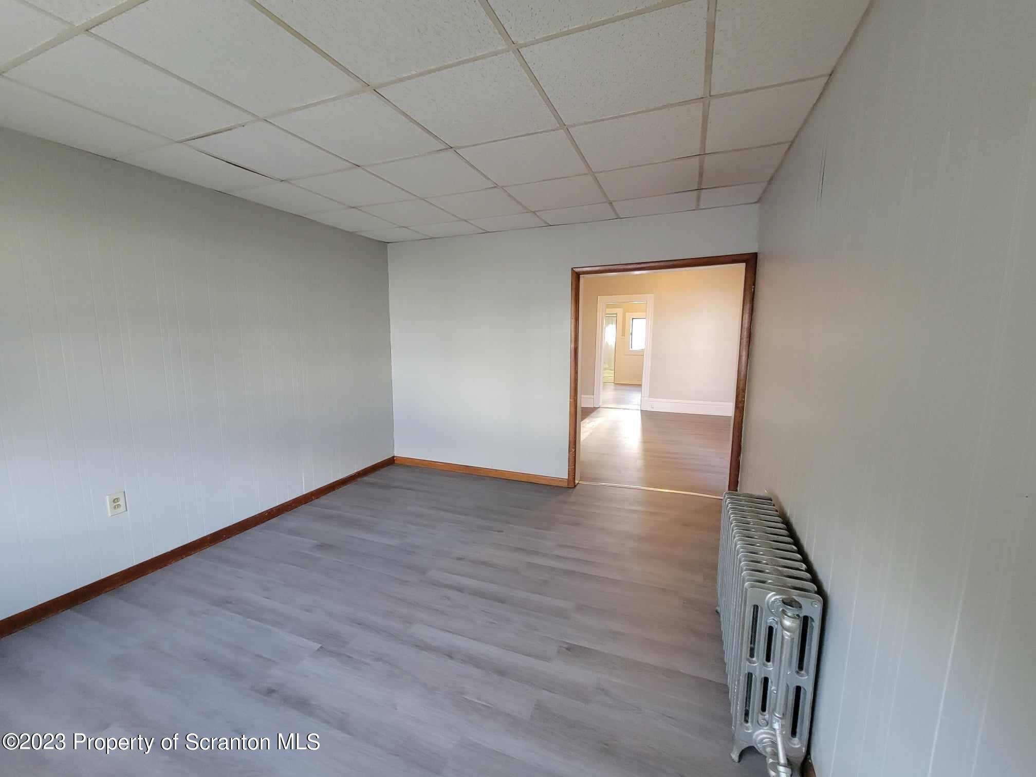 138 East Grove Street Taylor, PA 18517 - Photo 5 of 17 a view of an empty room with wooden floor and a window