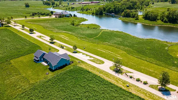 an aerial view of a residential houses with outdoor space and lake view