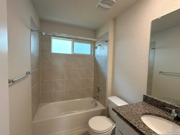 a bathroom with a granite countertop toilet sink and shower