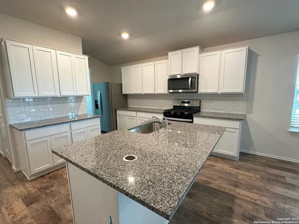 a kitchen with stainless steel appliances granite countertop a sink stove and microwave