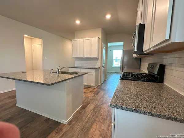 a kitchen with stainless steel appliances granite countertop a sink stove and cabinets