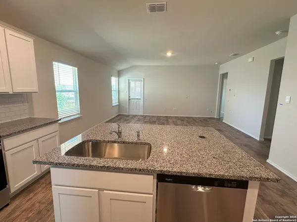 a kitchen with granite countertop a sink and cabinets