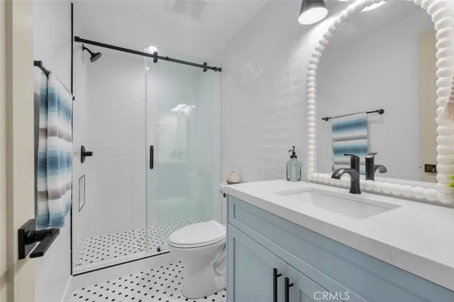 a bathroom with a sink a toilet and shower