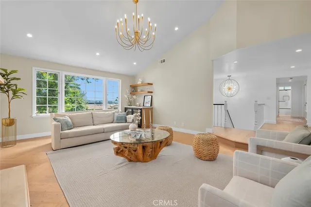 a living room with furniture kitchen and a large window