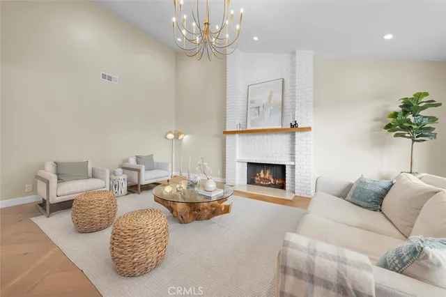 a living room with furniture a fireplace and a chandelier