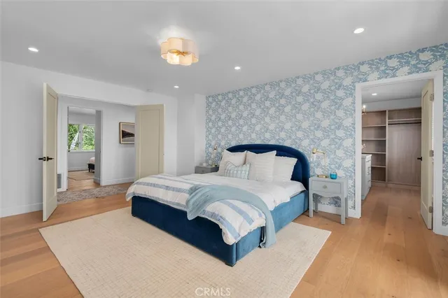 a spacious bedroom with a bed and a chandelier