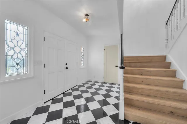 a view of a entryway with wooden floor and a chandelier