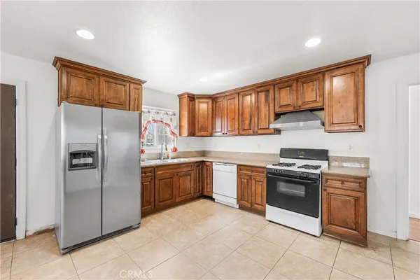 a kitchen with stainless steel appliances granite countertop a refrigerator stove and sink