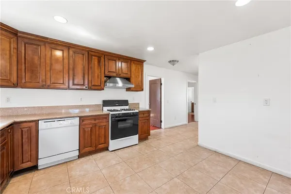 a kitchen with stainless steel appliances granite countertop a stove top oven a sink and dishwasher