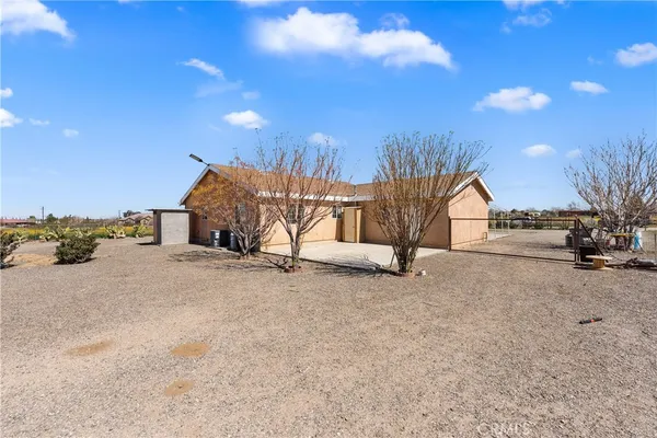 a view of a house with backyard and a tree
