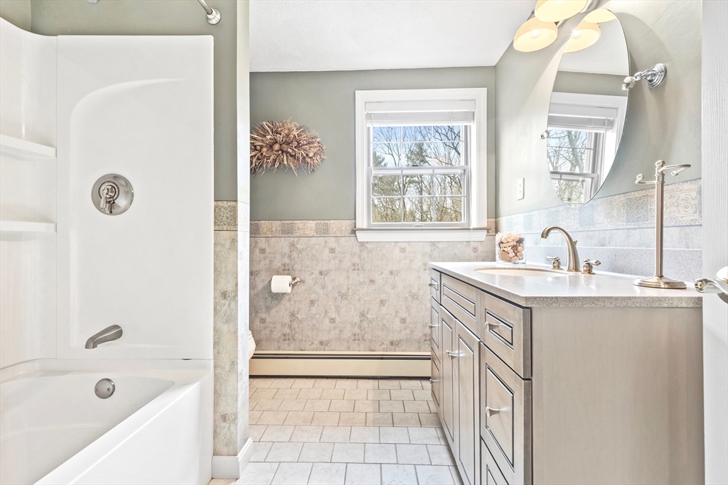 116 River Street Middleton, MA 01949 - Photo 24 of 32 a bathroom with a granite countertop sink a mirror a bathtub and next to a window