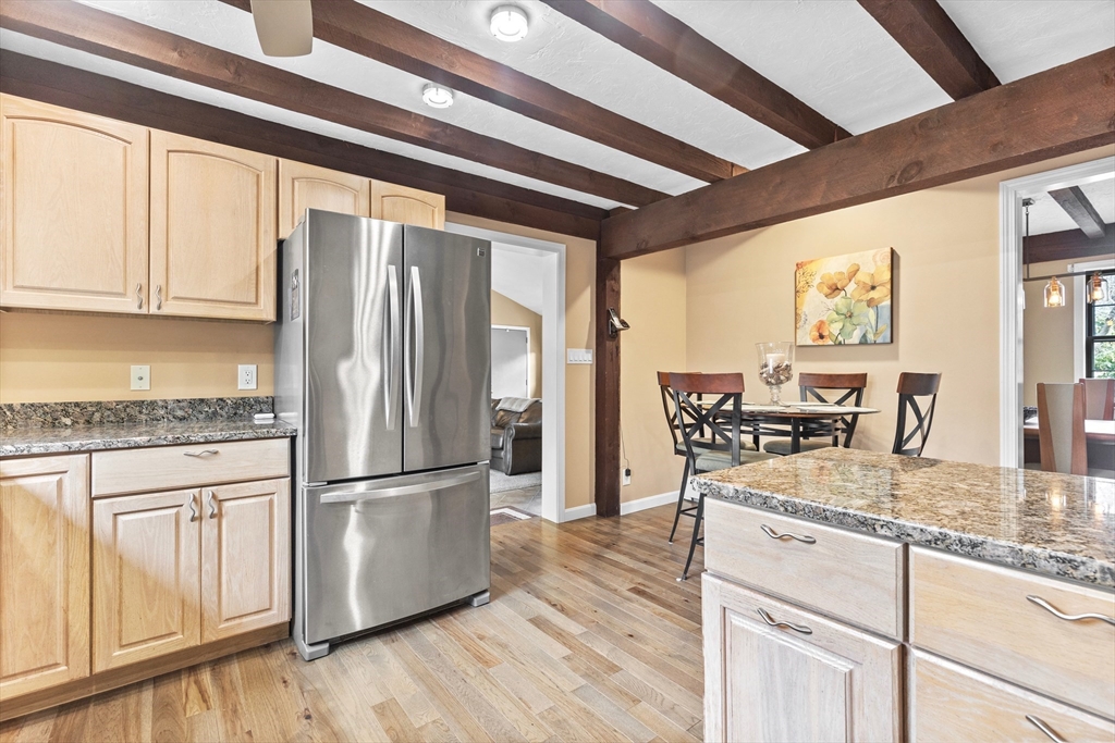 116 River Street Middleton, MA 01949 - Photo 7 of 32 a kitchen with granite countertop a refrigerator a sink and white cabinets