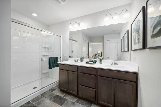 a bathroom with a double vanity sink mirror and shower