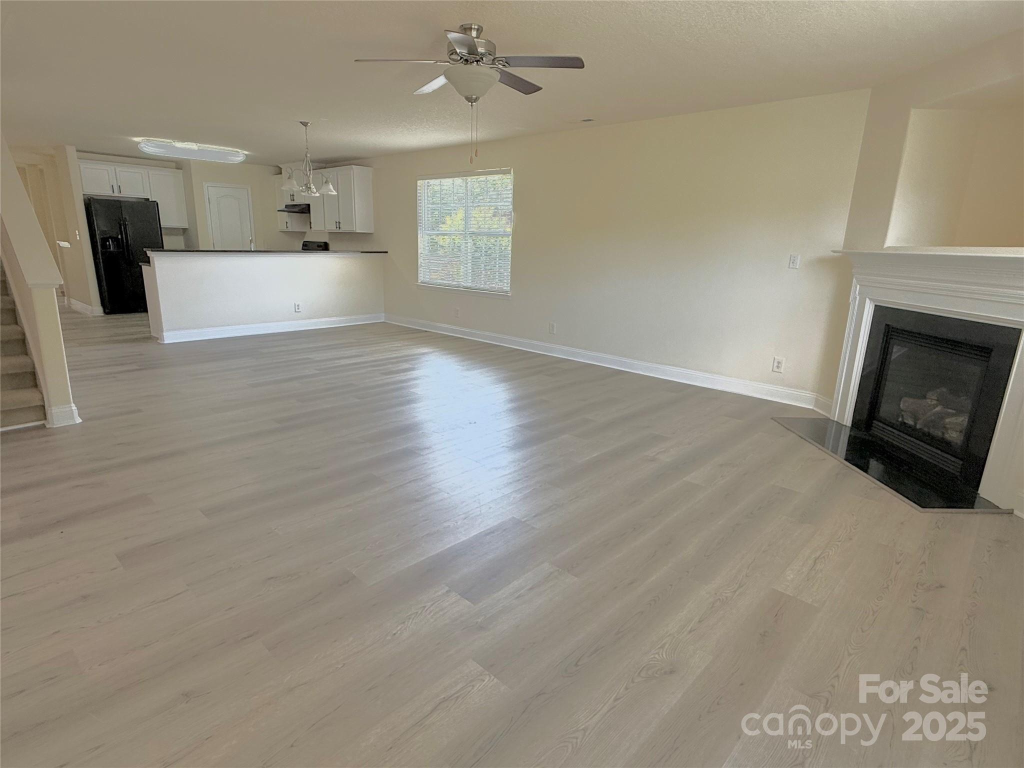 7534 April Mist Trail Huntersville, NC 28078 - Photo 12 of 47 a view of a kitchen and an empty room with a fireplace