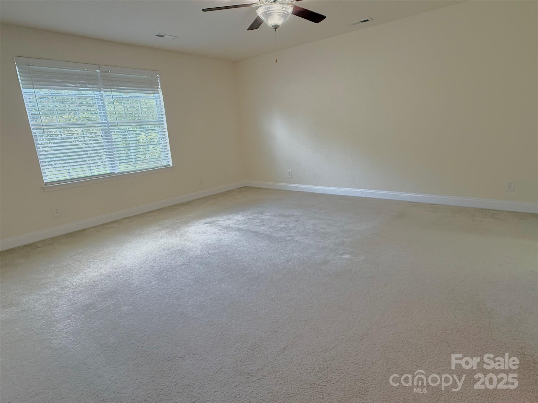 7534 April Mist Trail Huntersville, NC 28078 - Photo 15 of 47 an empty room with a window and a ceiling fan