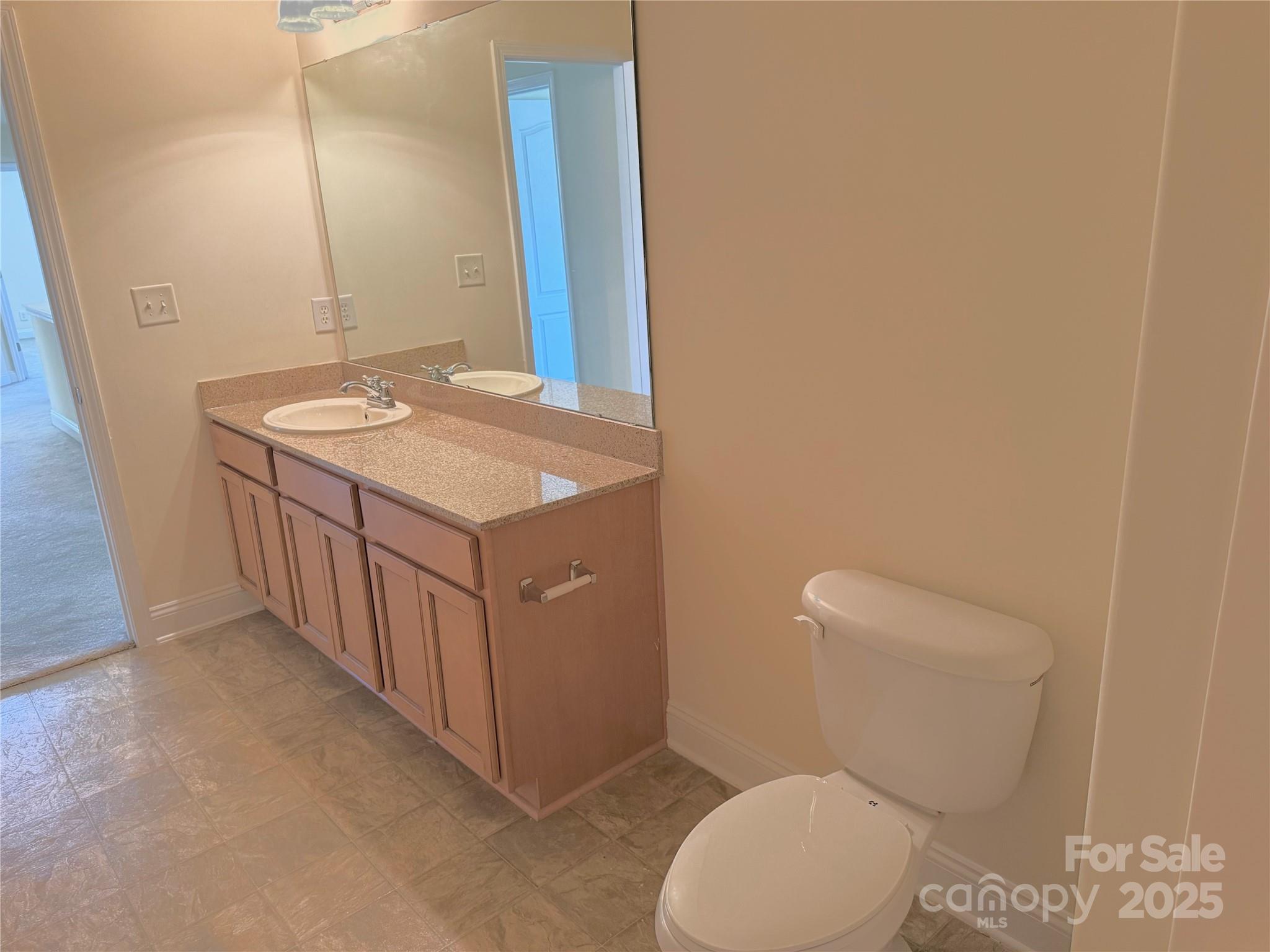 7534 April Mist Trail Huntersville, NC 28078 - Photo 43 of 47 a bathroom with a granite countertop toilet and a sink