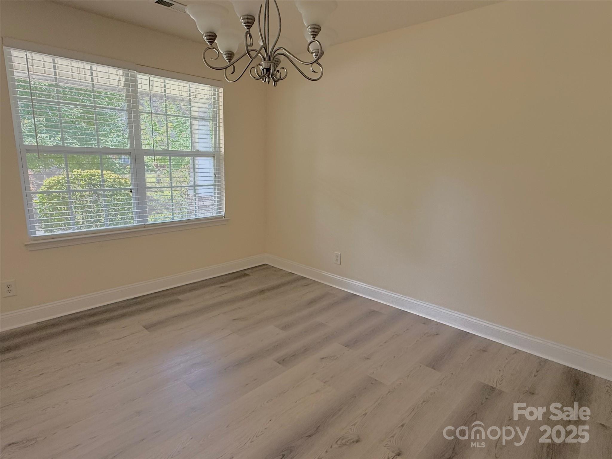 7534 April Mist Trail Huntersville, NC 28078 - Photo 5 of 47 an empty room with wooden floor and windows