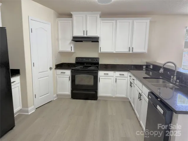 a kitchen with a sink stove and cabinets